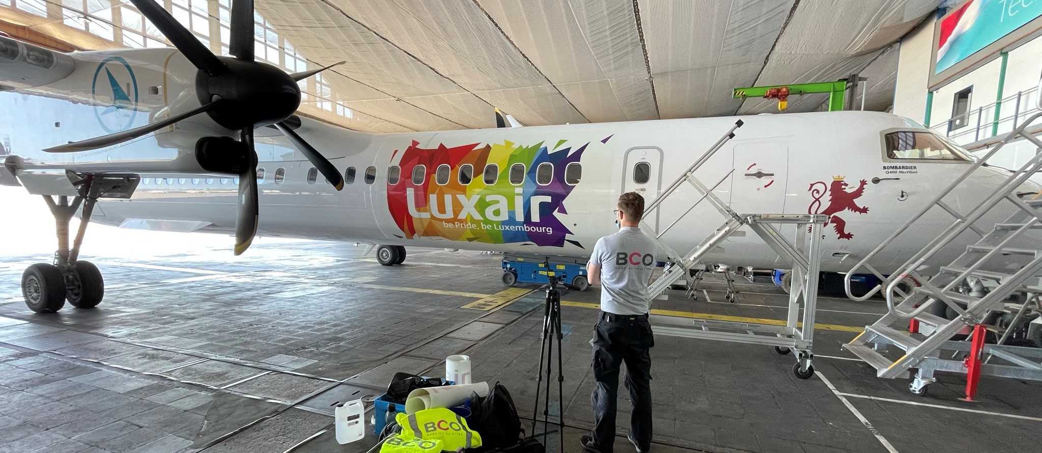 Illustration for: We installed a colourful new aircraft livery on De Havilland Q400 for Luxair Airlines (Video)